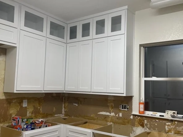 Cabinet install — Glass-front uppers hung and levelled
